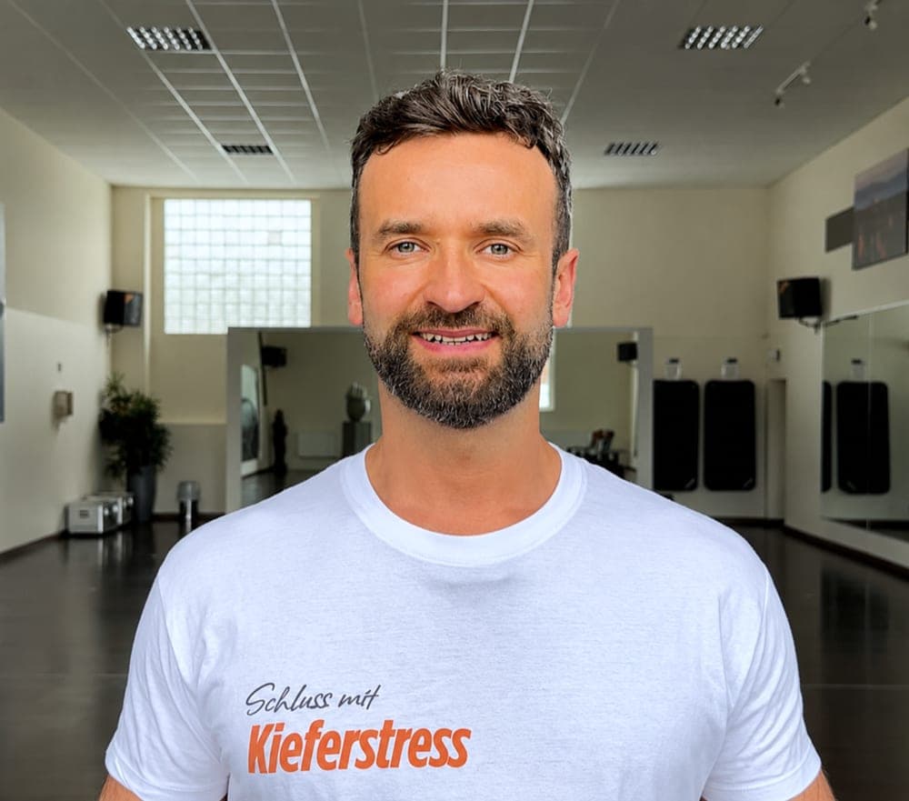 Robert Lazik im Trainingsraum, im T-Shirt mit dem Schriftzug Schluss mit Kieferstress